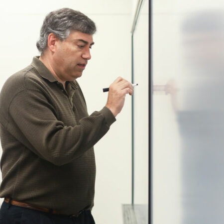 Faculty member writing something on board
