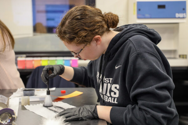 Student in crime lab dusting for prints