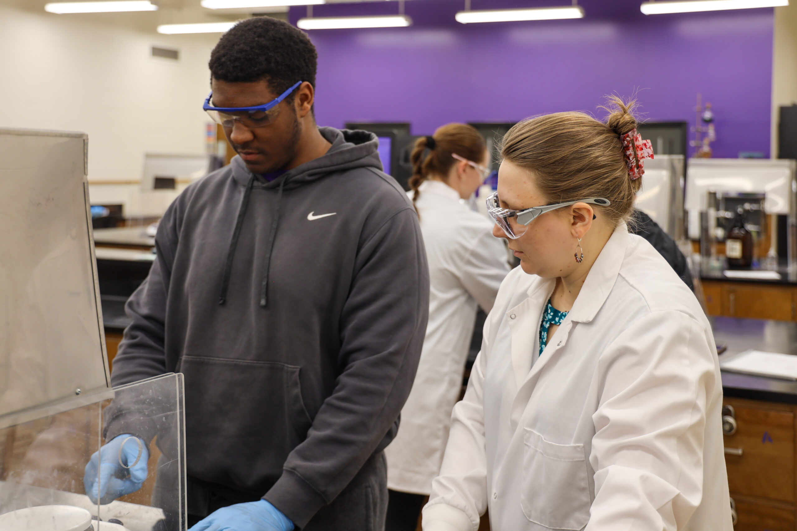 Instructor observes chemistry student