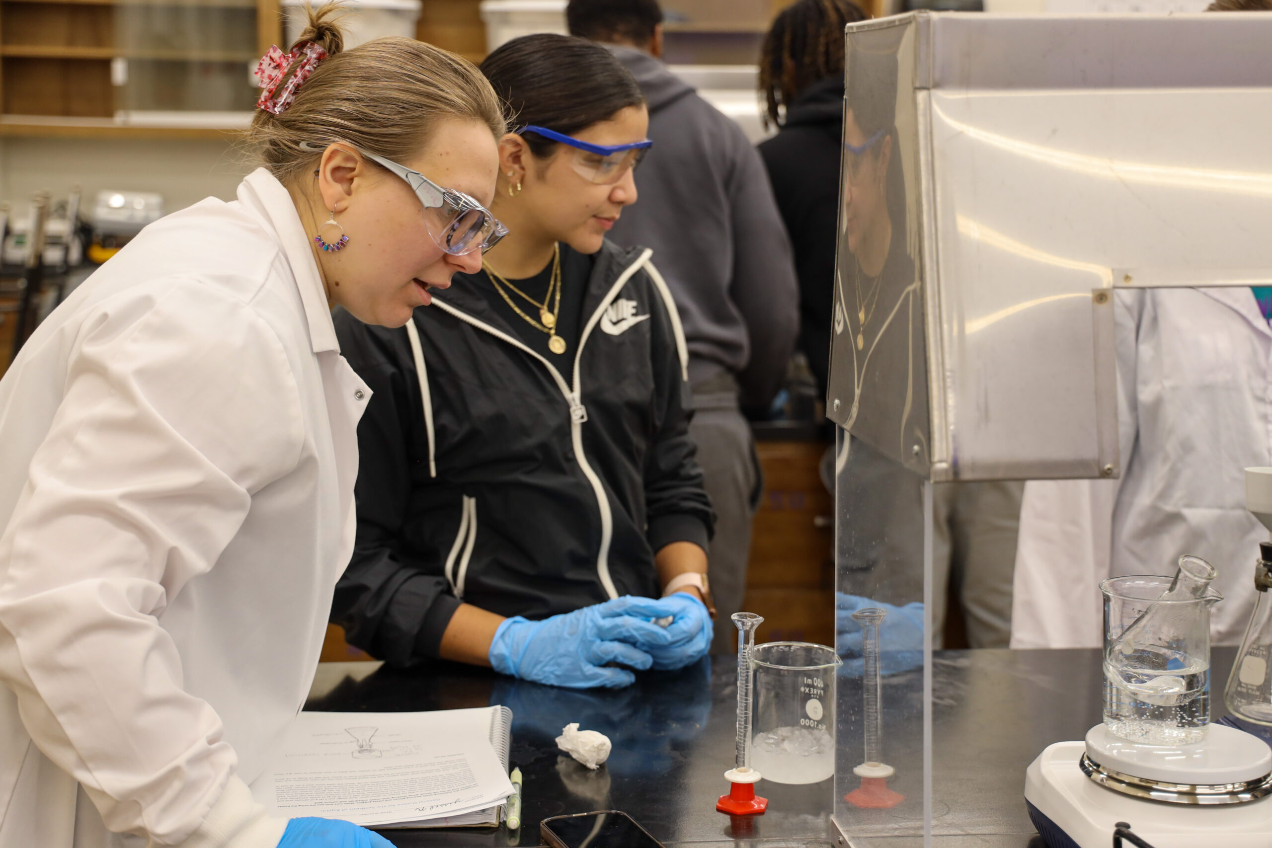 Chemistry instructor observing student's work