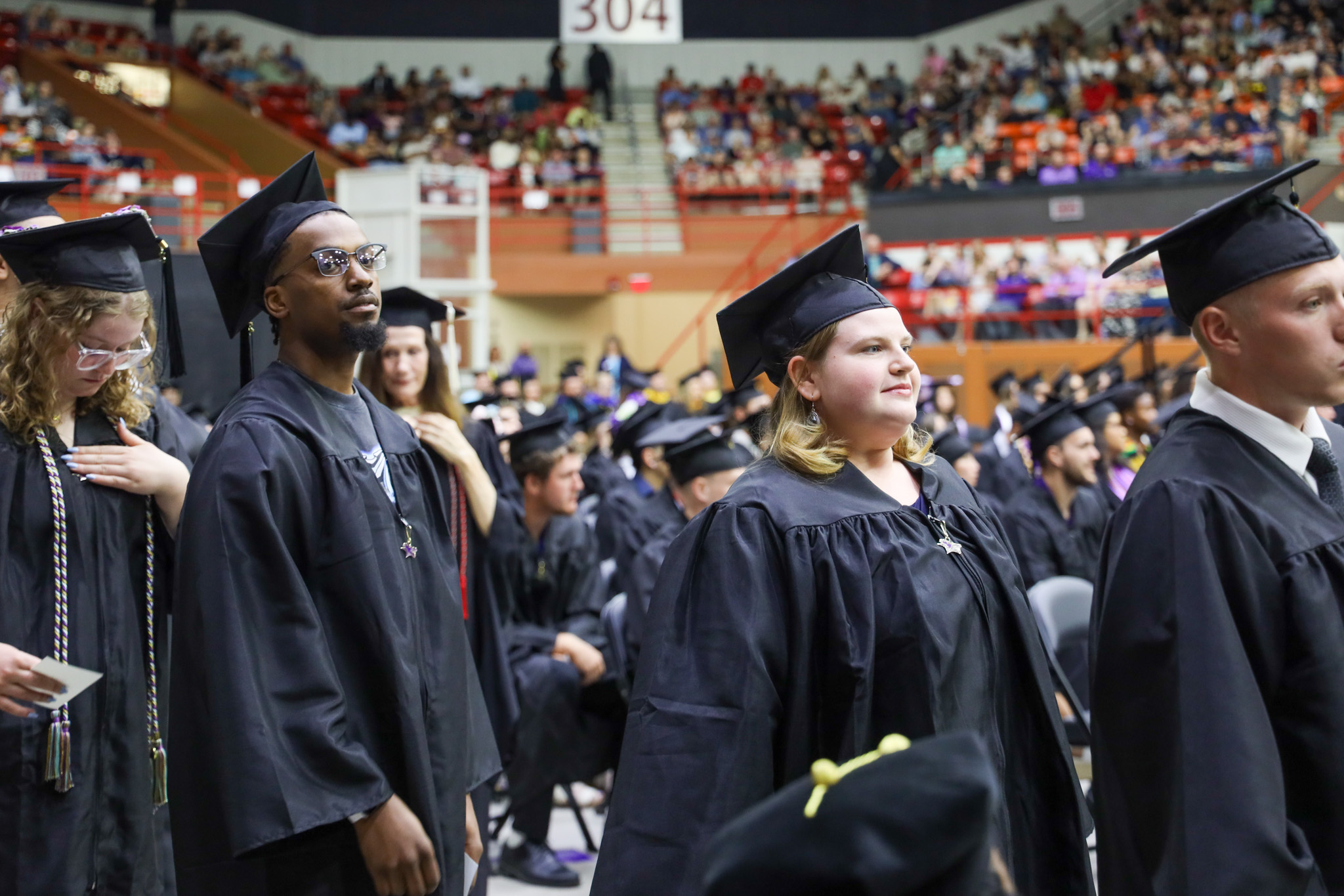 Graduates standing at commencement