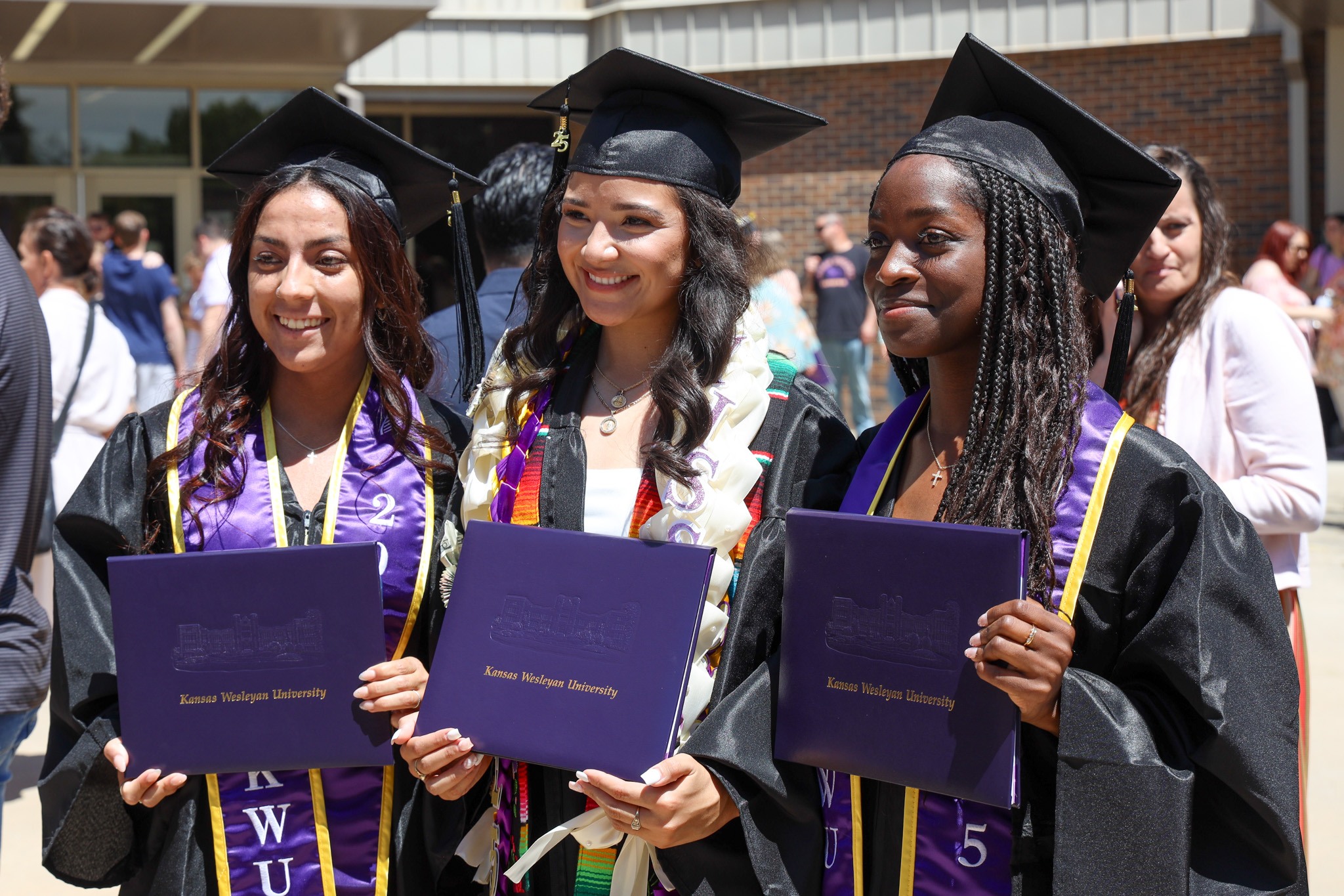 Trio of students posing with diplomas