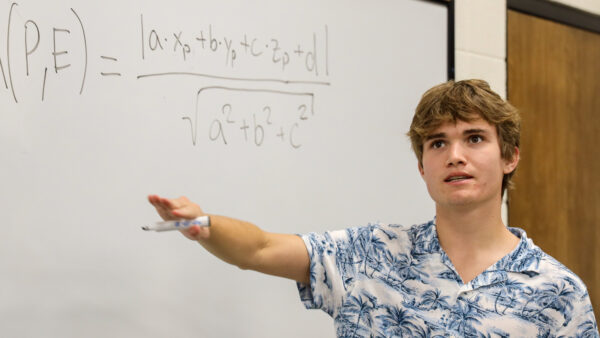 Student with math problem at whiteboard