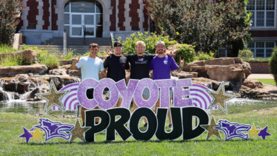 Group of people gathered behind KWU sign