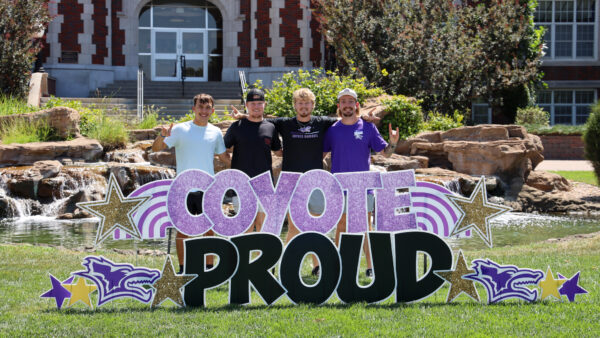 Group of people gathered behind KWU sign