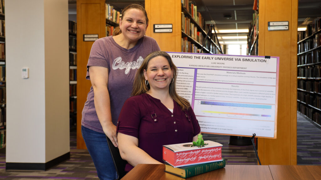 Two women posing in a library