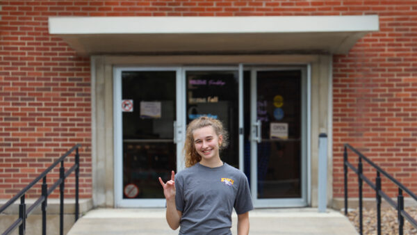 Student standing in front of the library