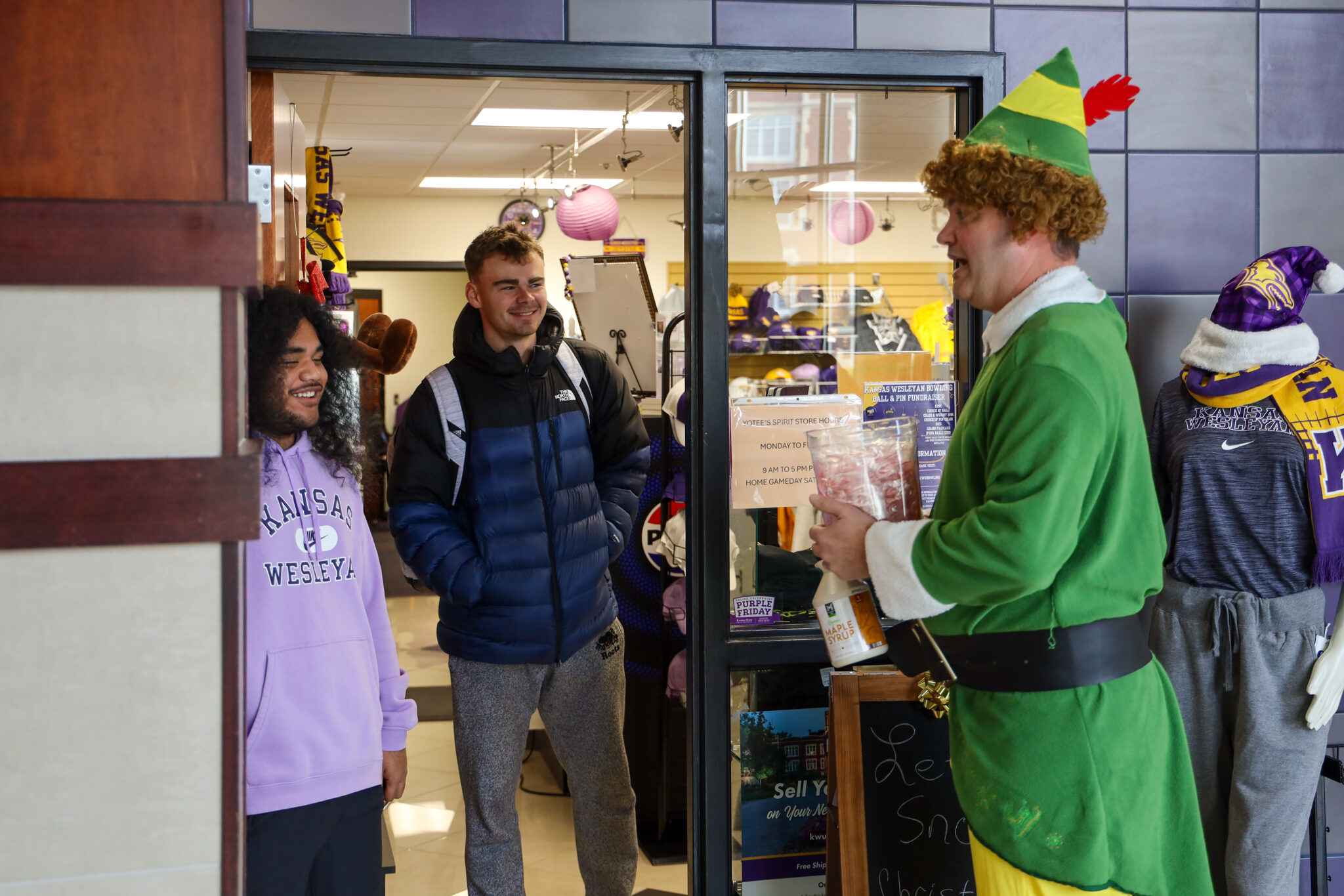 Man in elf costume talking to students