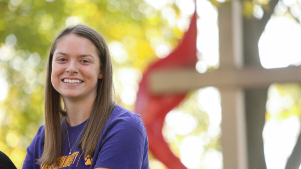 Female student sitting in front of cross