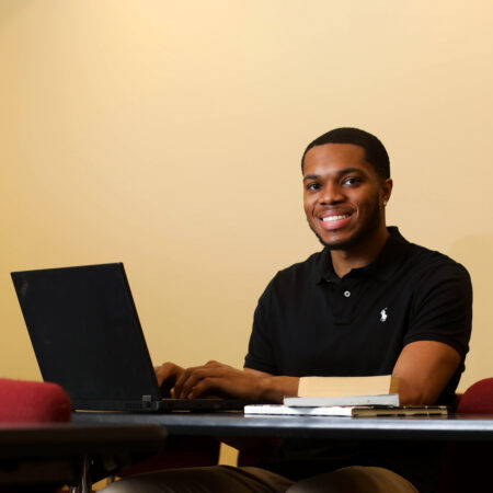 Man by computer smiling