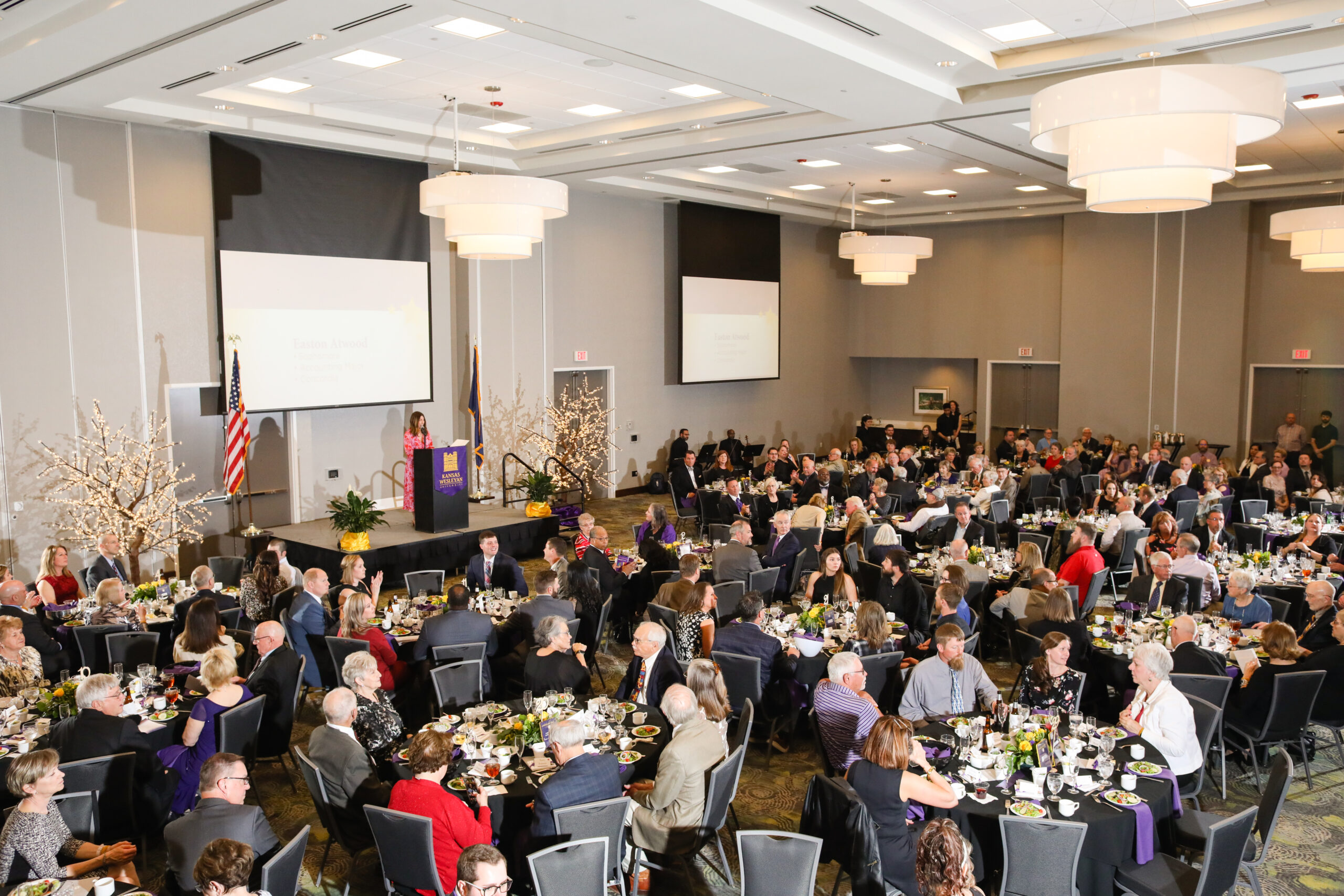 A crowd sits and listens to a speaker
