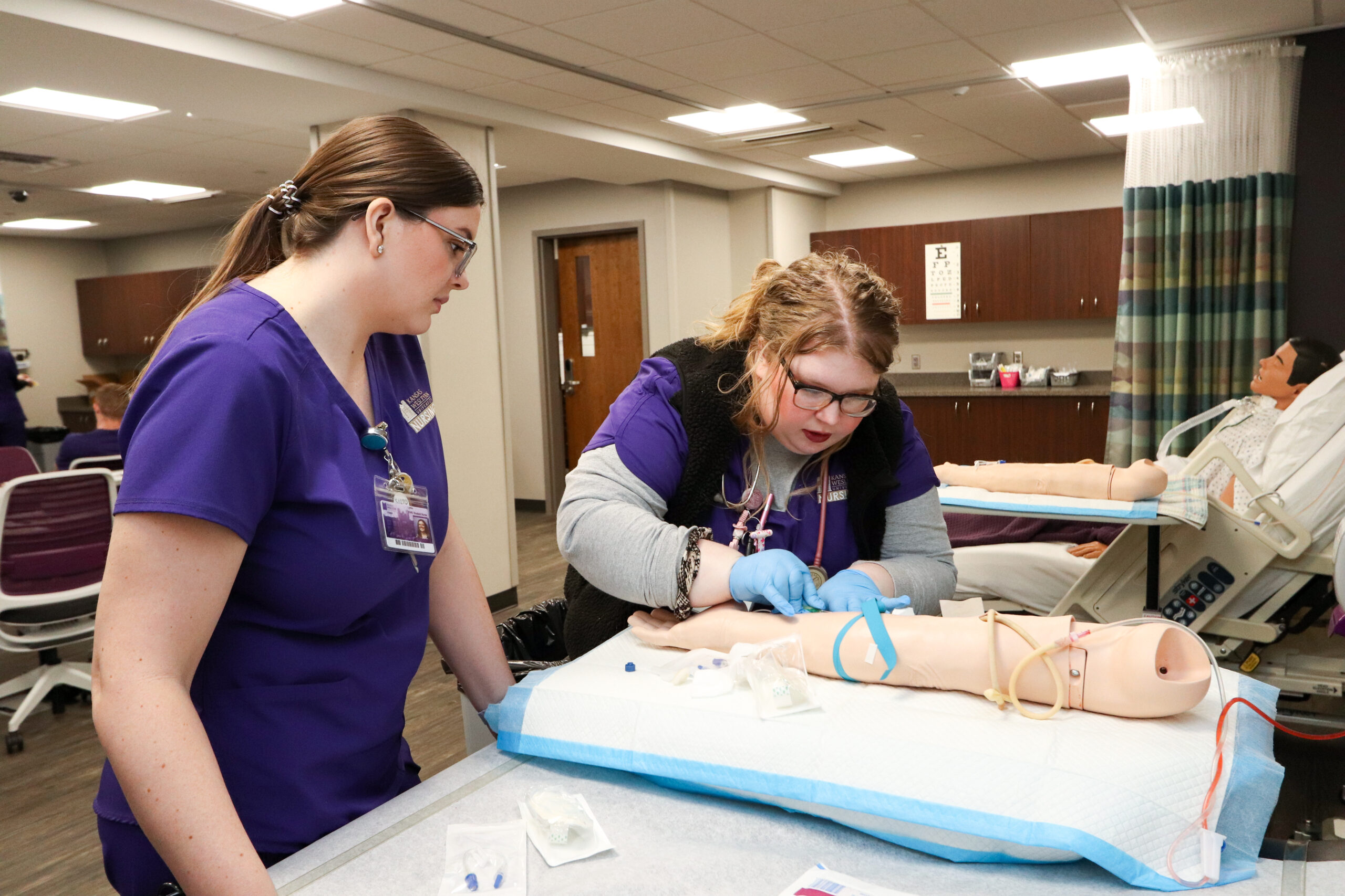 Students performing mock test on a patient's arm