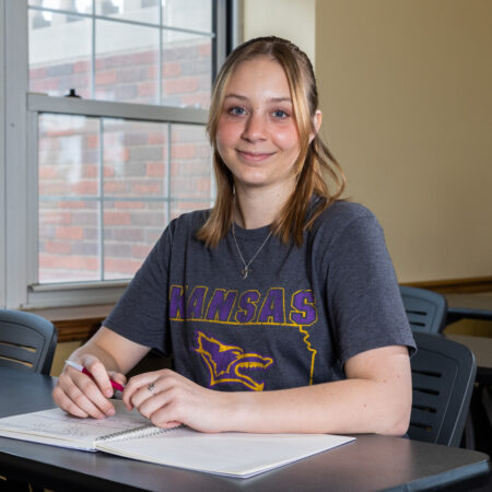 Woman sitting in class with notebook