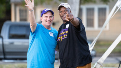 Two men pointing and waving