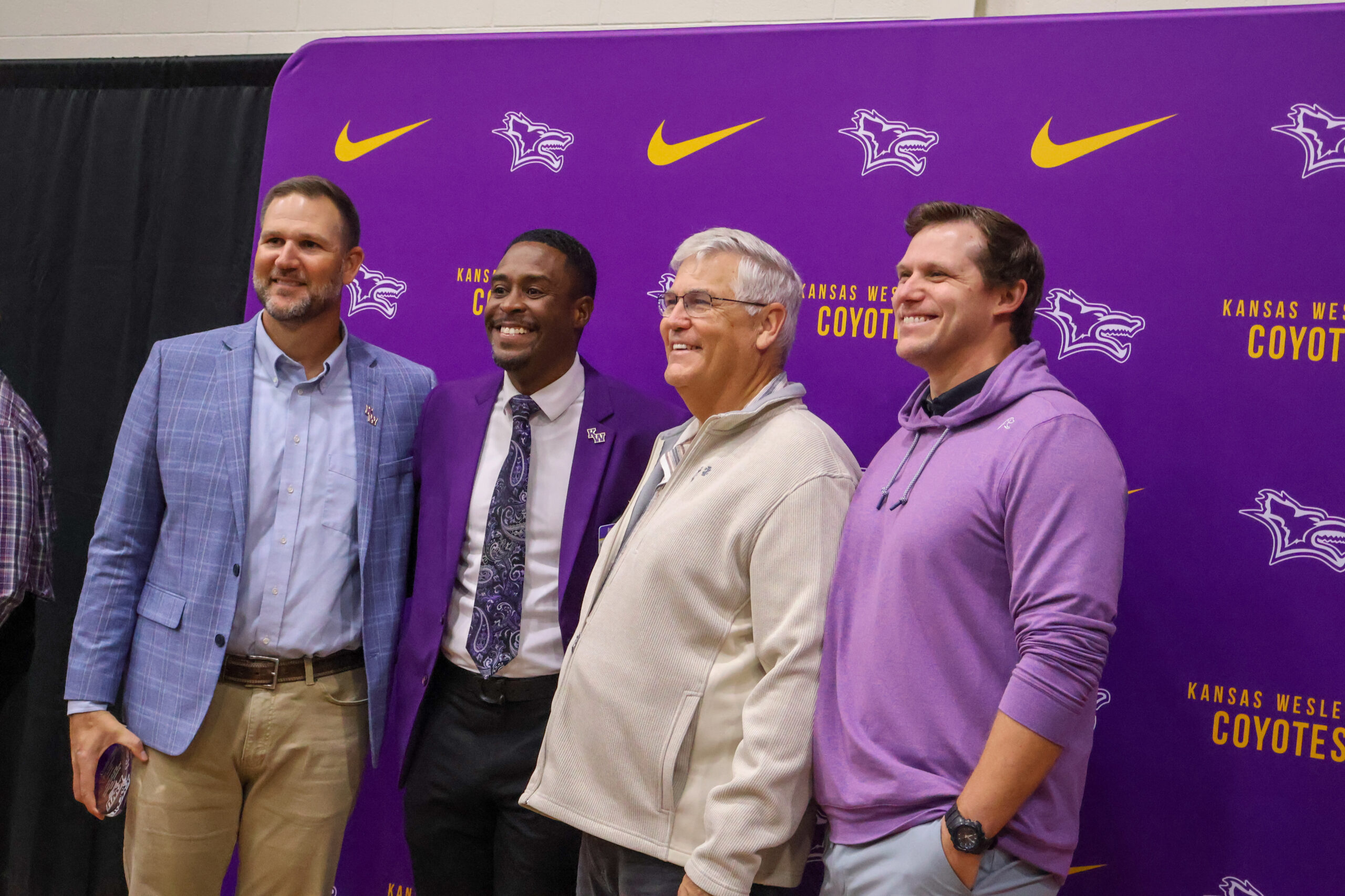 Group of four men in front of backdrop