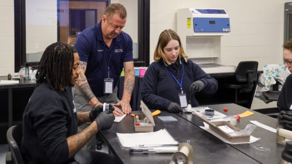 Instructor and students in CSI crime lab