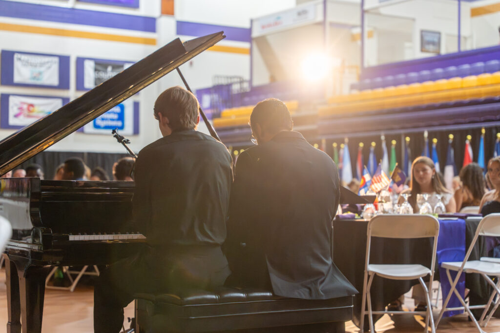Two people playing piano