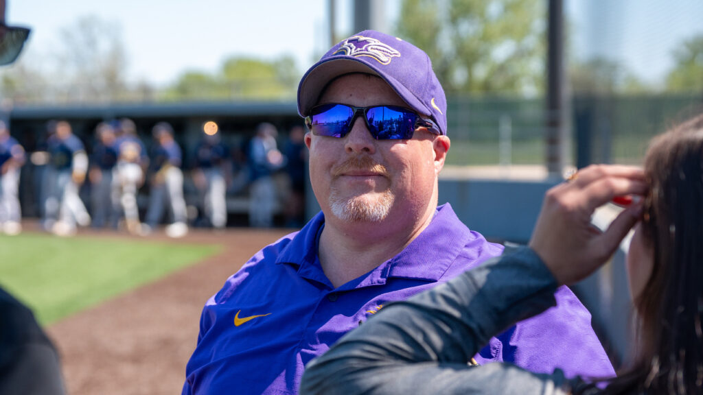 Man in sunglasses prepares to throw out first pitch