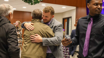 Graduate hugging other person