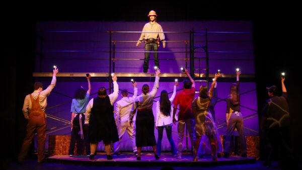 Man on scaffolding with others below - Working musical