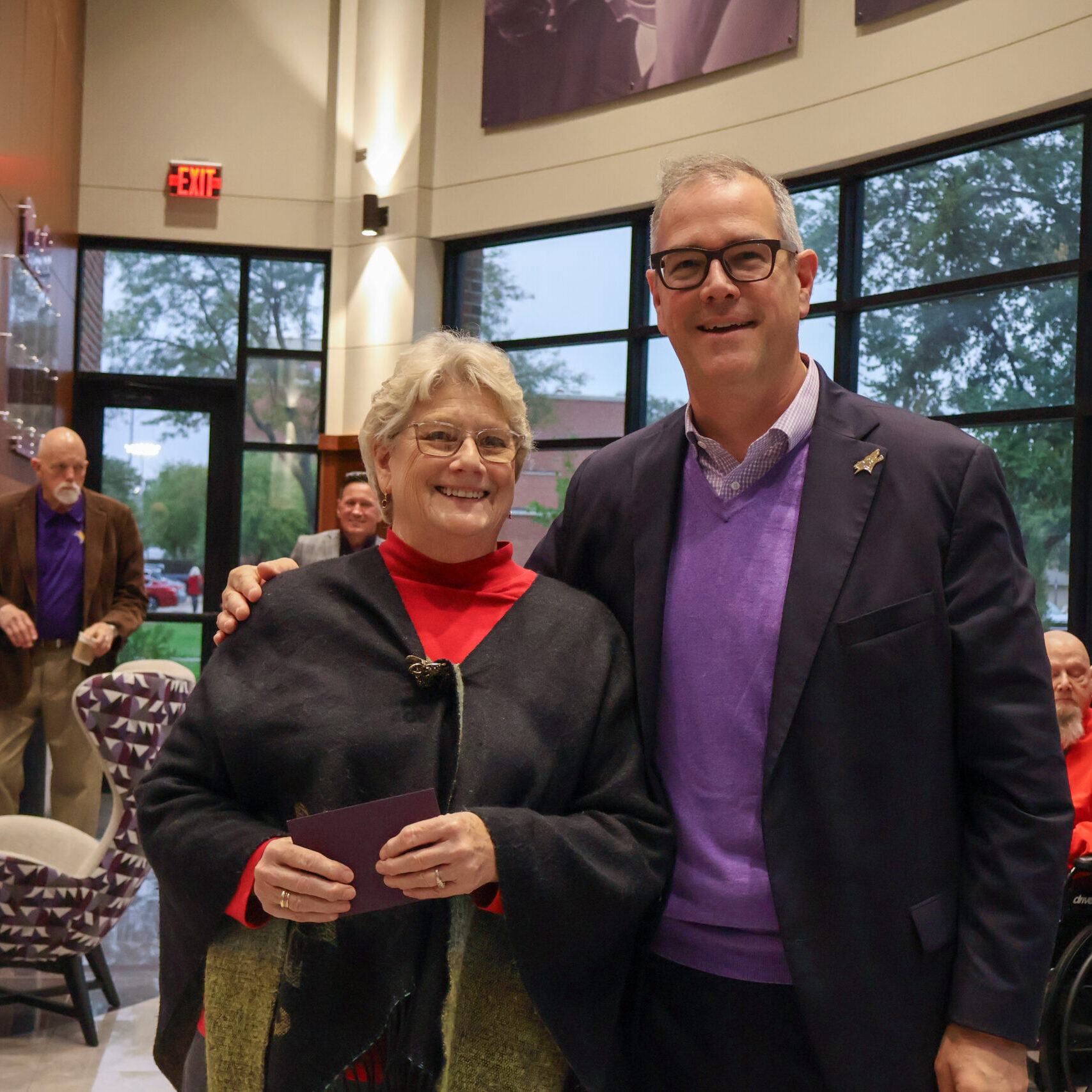 Man standing by woman with award