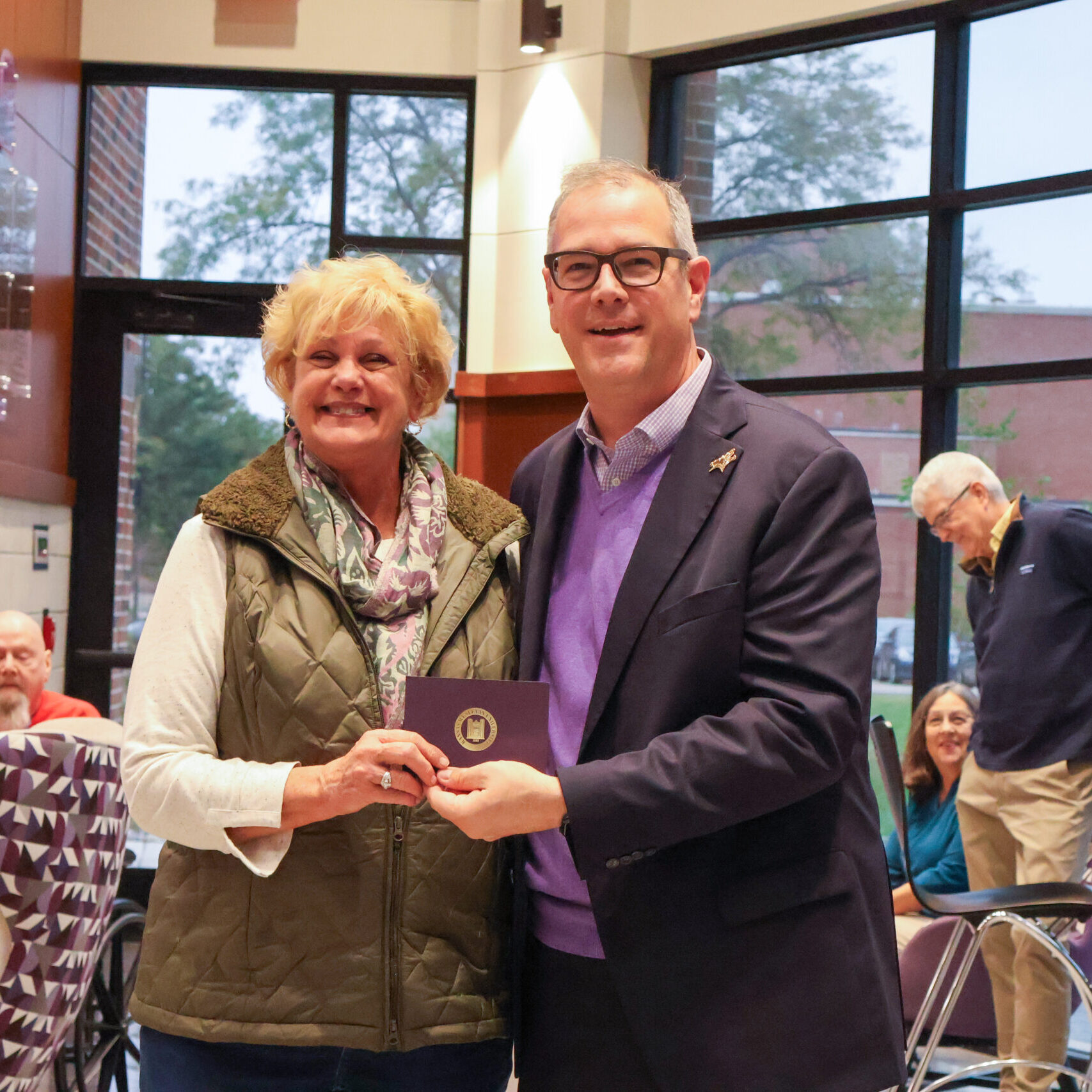 Man standing by woman with award