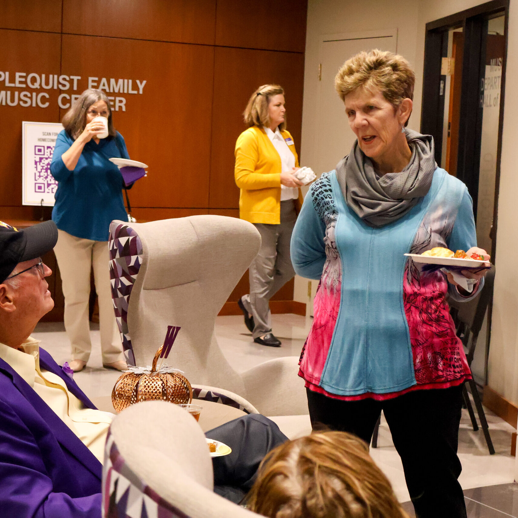 Woman standing talking to seated man