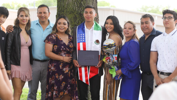 Graduate with family by tree