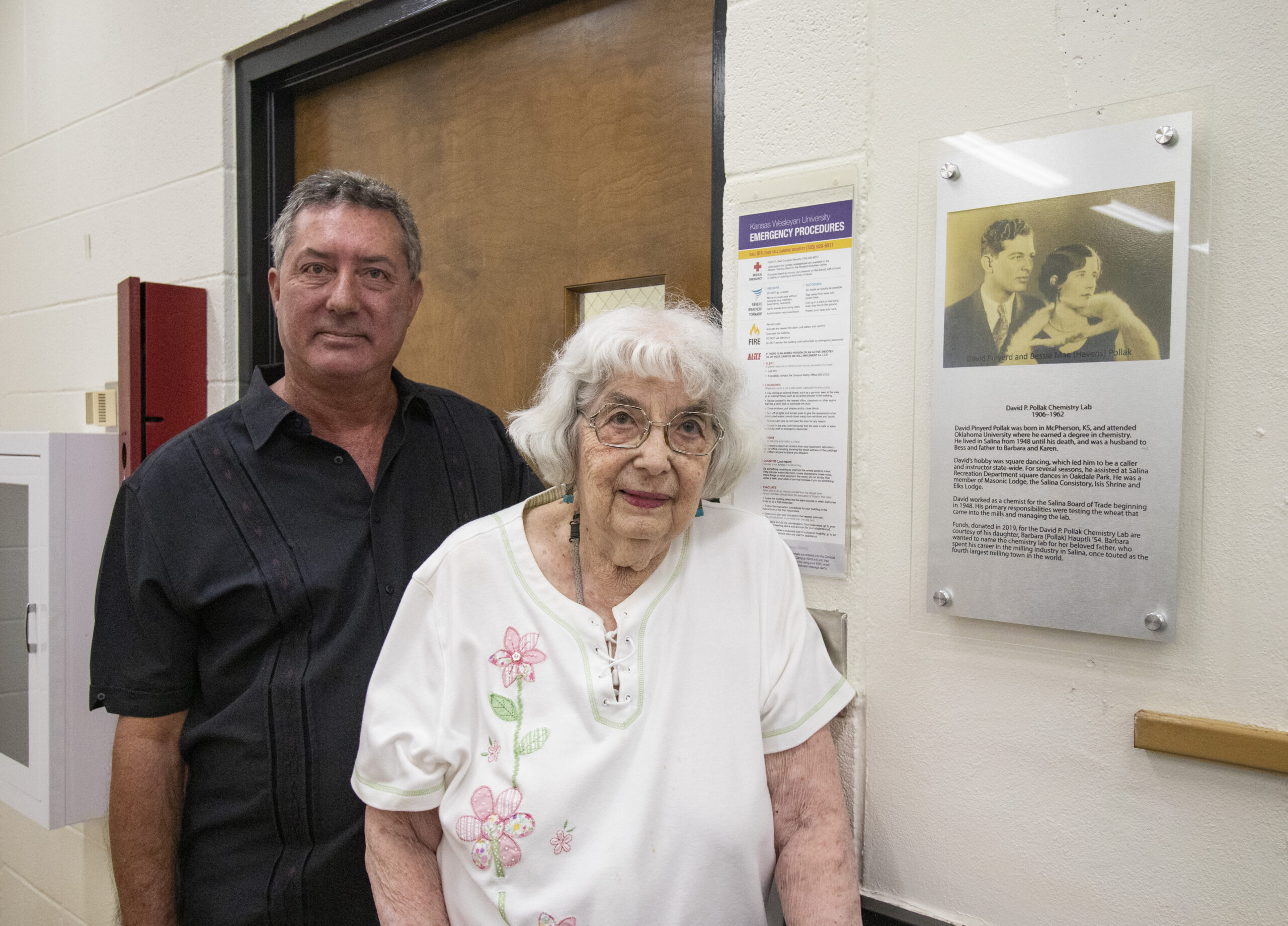 Barbara (Pollak) Hauptli and son pose outside chemistry lab