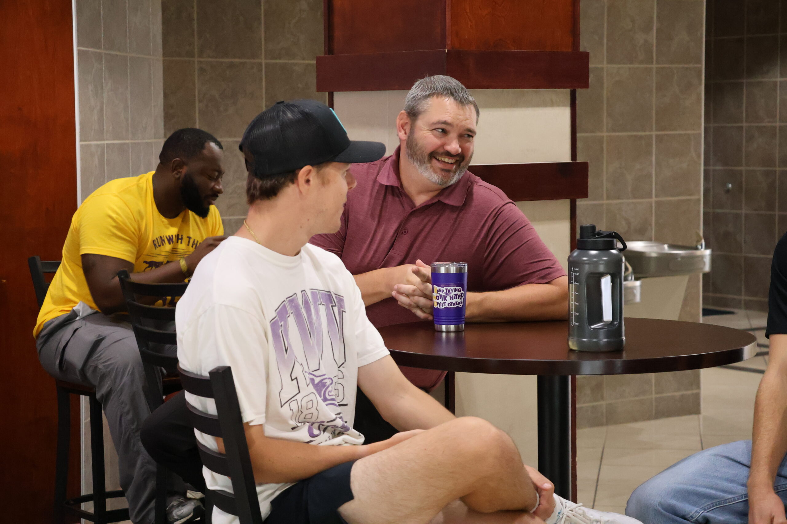 Man sitting at table with male students