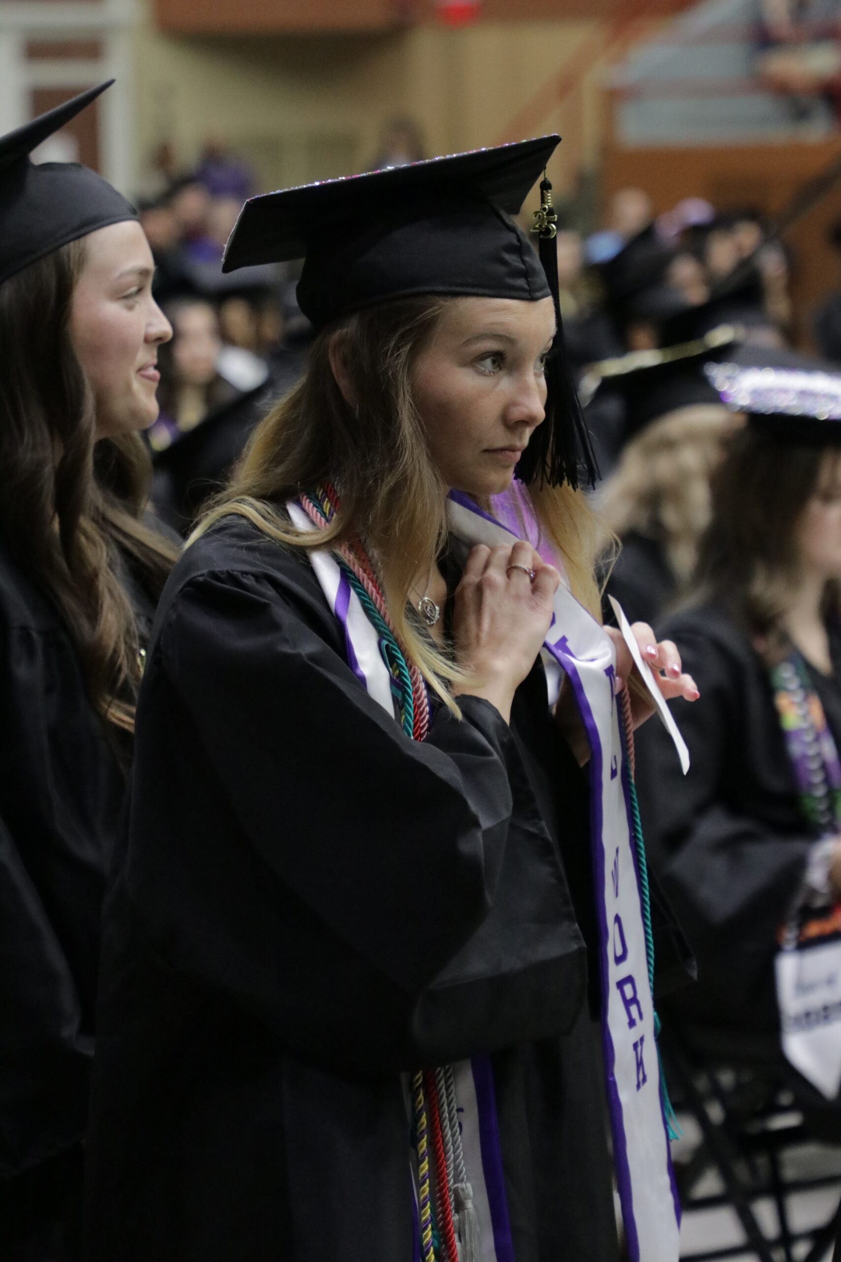 Woman adjusting part of cap and gown