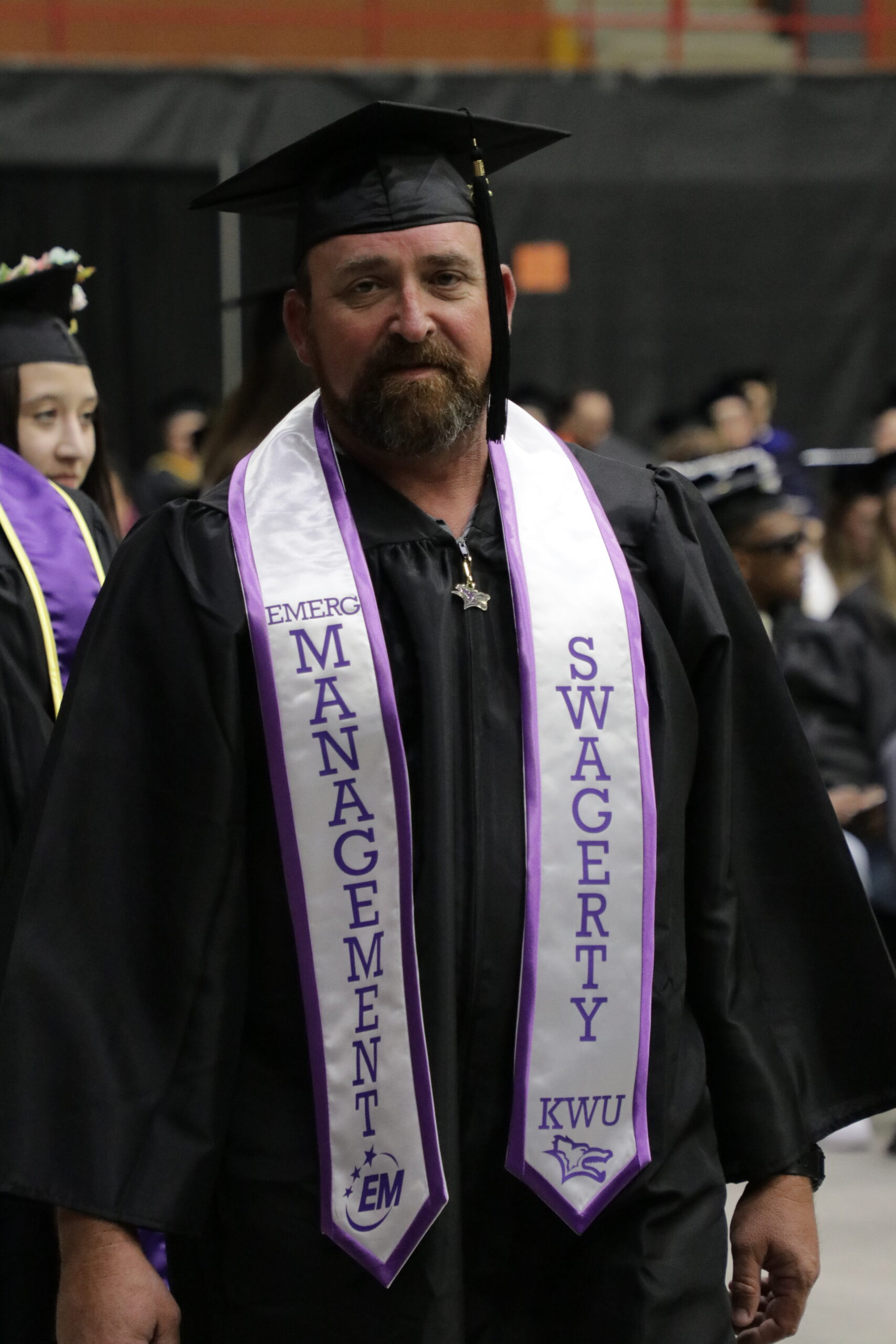 Man in cap and gown staring at camera