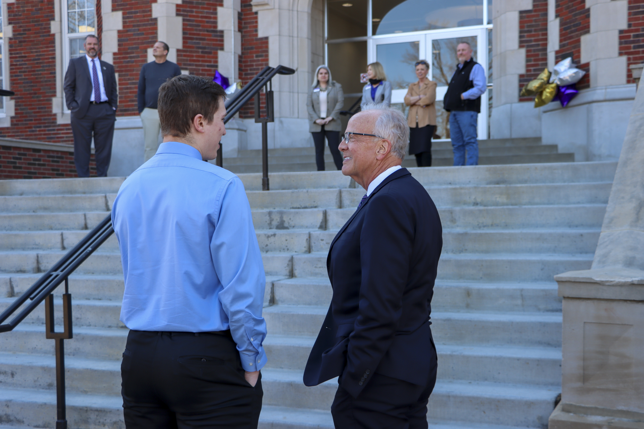 Man talking with student near steps