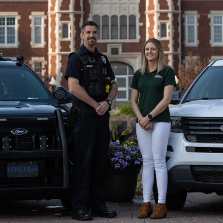 Police officer and county official in front of vehicles