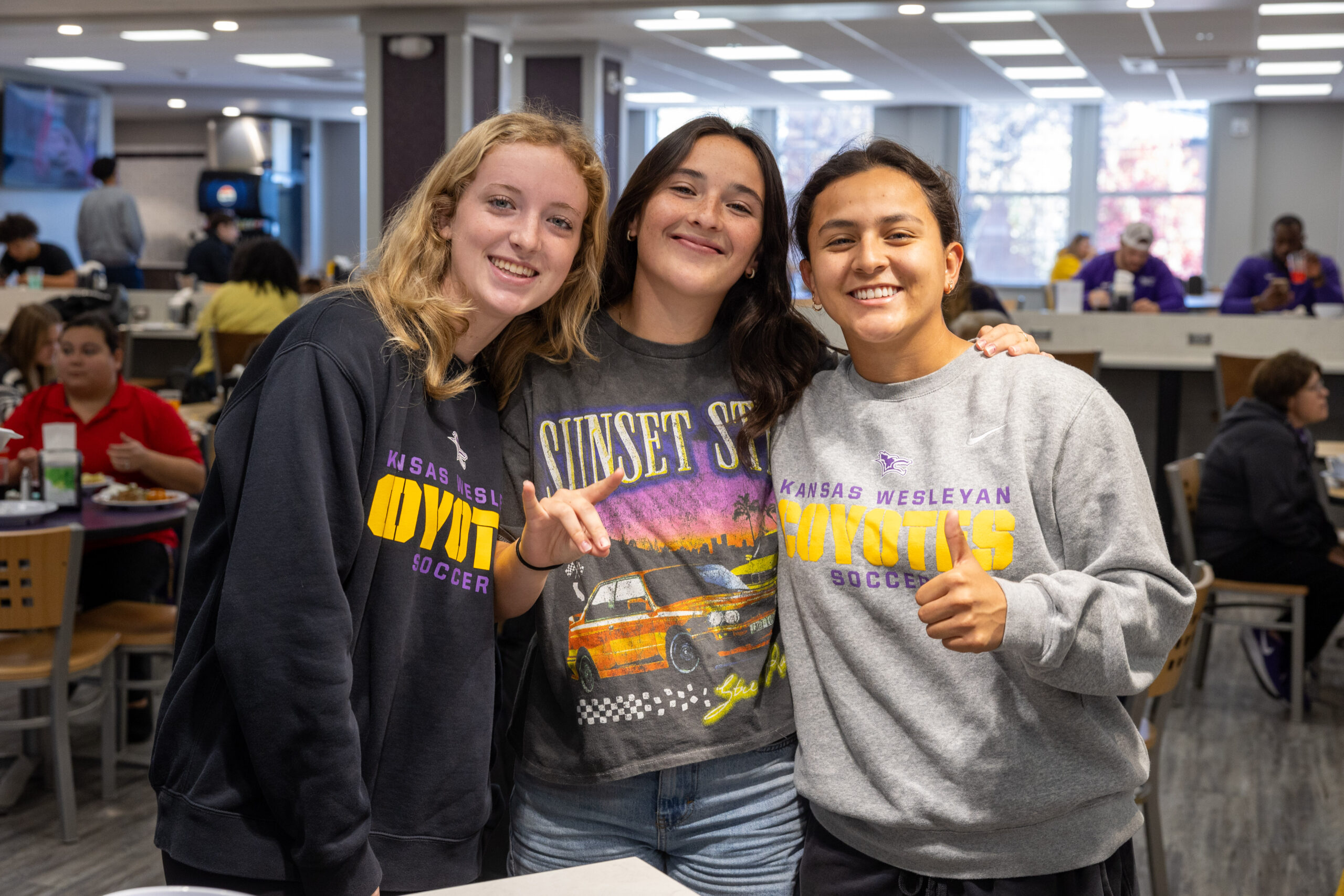 Three students pose for picture in dining hall