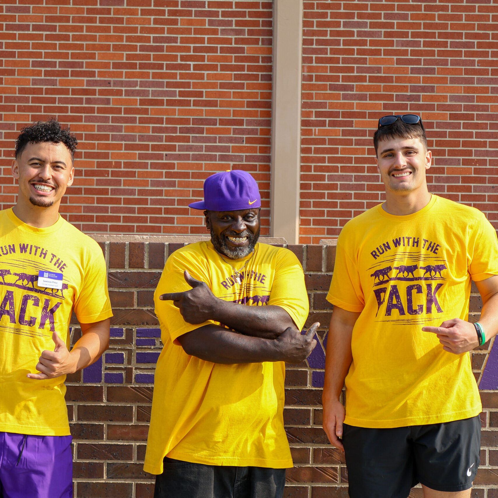 Three men standing outside residence hall