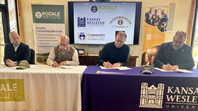 Men at tables signing documents