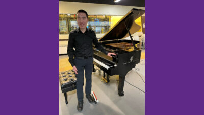 Man standing next to Piano