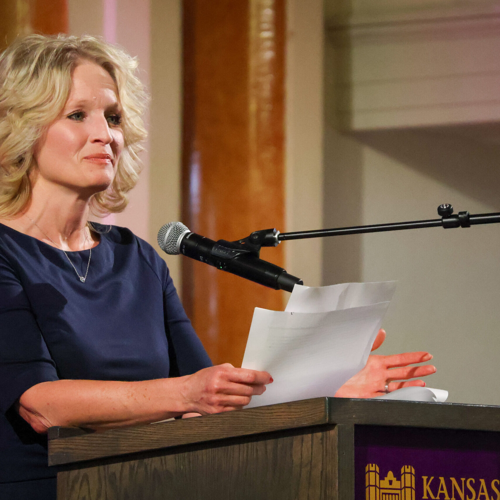 Woman reading speech on stage