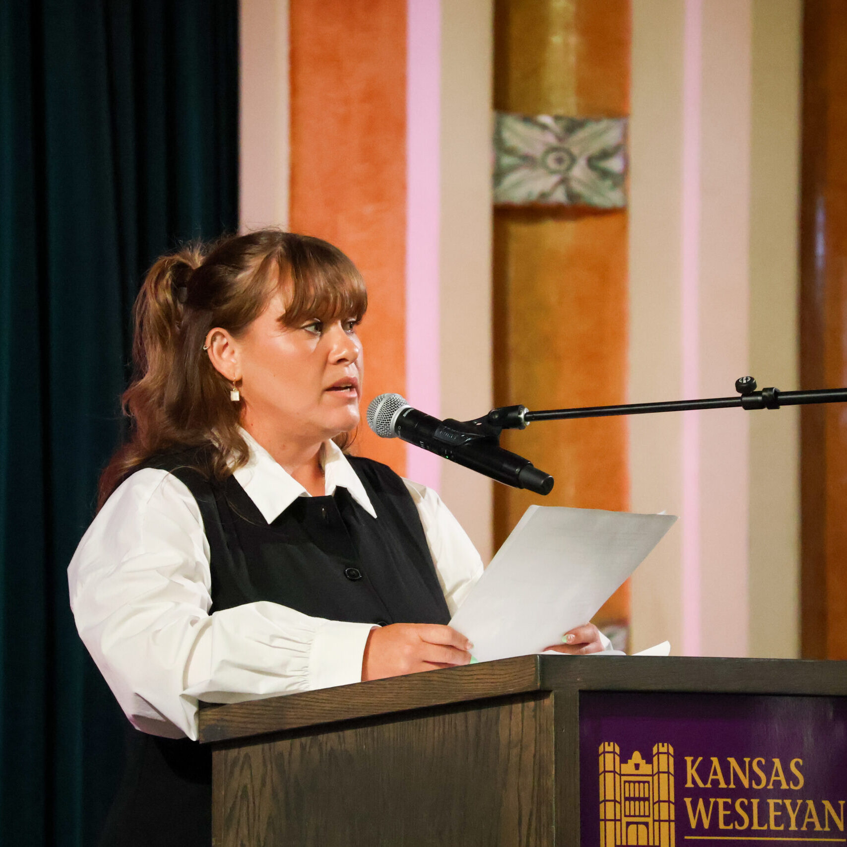 Woman reading speech on stage