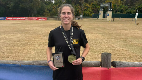 Female runner standing with plaque and medal