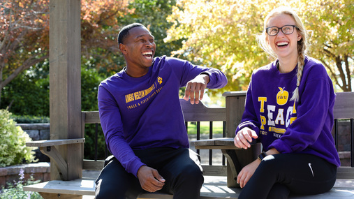 Man and woman sitting on bench laughing