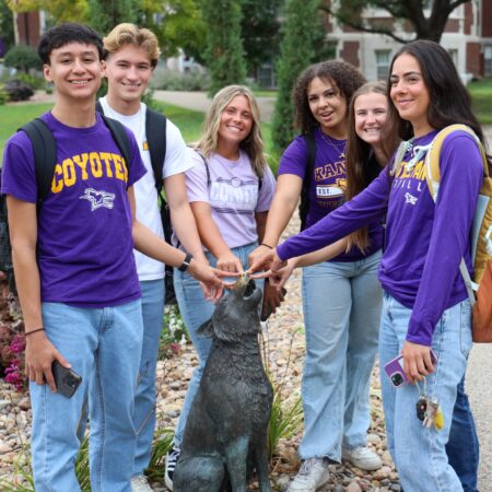 Students gathered around statue on campus