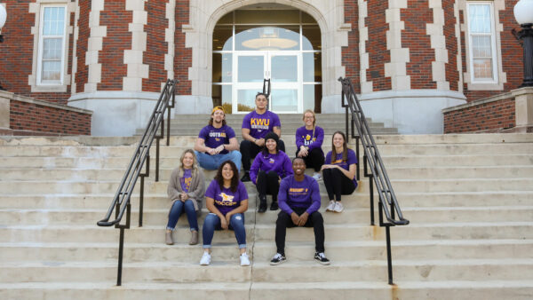 Students sitting on front steps of building